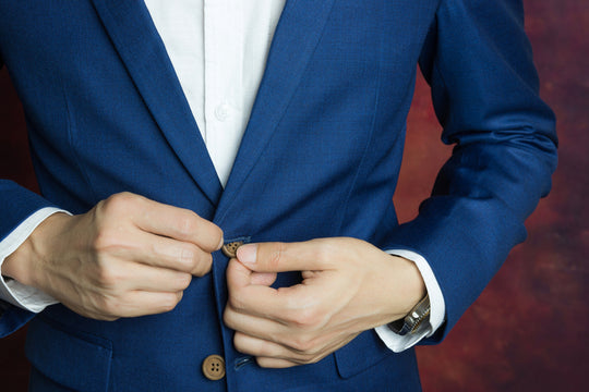 man closing suit button