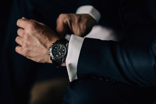 man in suit putting his watch on.